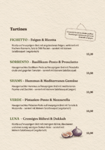 Speisekarte des Tartine Cafés: Auswahl an herzhaften Krustenbrot-Tartines wie Fichetto mit Feigen und Ricotta, Sorrento mit Basilikum-Pesto, Shams mit Hummus, Verde mit Pistazien-Pesto und Luna mit Rührei.